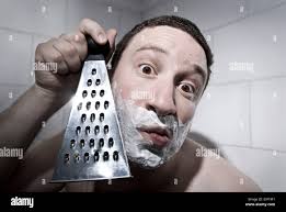 a funny photo of a man shaving with a cheese grater Stock Photo