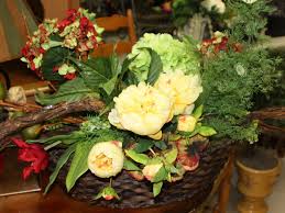 A feathered rooster mingles amoung gold mini hydrangea blossoms, red poppies and berries and a variety of greenery stems in this four sided centerpiece floral arrangement. Portfolio Wisteria Flowers And Gifts
