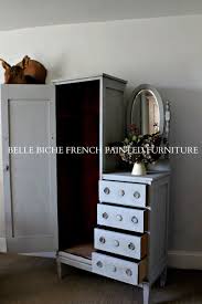 Hanging space, shelves above with glass sliding doors and two drawers below. Antique Tallboy Nursery Wardrobe Belle Biche Interiors