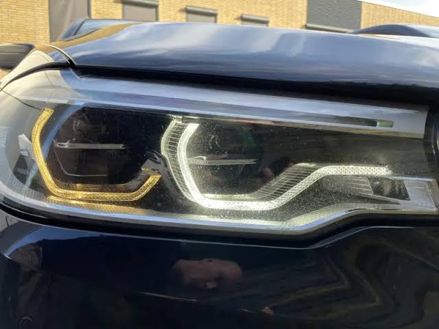 Vehicle before paint protection film application showing paint swirls and light damage