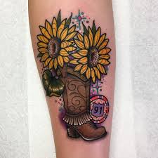 Black ink cowboy boot with hat tattoo on upper back. Roberto Euan Tattoo Artist Tattoodo