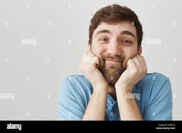 Man can not look away watching cute couple of cats. Portrait of gentle and  nice mature bearded guy holding hands