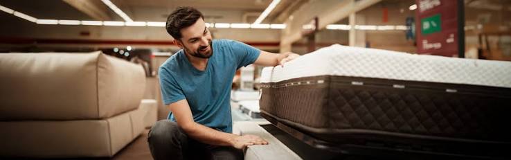 Customer testing a quality mattress in a furniture showroom in Mauritius