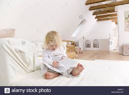 Wohnen Zimmer Sofa Kleinkind Madchen Sitzen Ansichten Buch Portrat Wohnung Hell Komfortabel Menschen Kind 1 2 Jahre Blond Barfuss Jedoch Kind Buch Liest Seiten Interesse Neugier Ganz Korper Kindheit Zu Hause Interieur