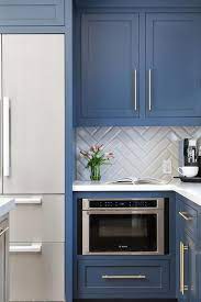 Installing a tile backsplash can add timeless beauty to your home. Blue Shaker Kitchen Cabinets With Brass Pulls Transitional Kitchen