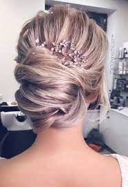 Romantic Bridal Updos Polished Wedding Hairstyle Idea Hair Bun Embellished With A Hairpiece Per Bridal Hair Updo Unique Wedding Hairstyles Wedding Haircut