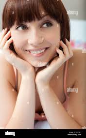 Donna Lone che guarda fuori dalla finestra della camera da letto Foto stock 