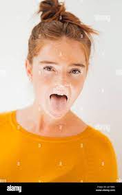 Playful woman sticking out tongue in studio Stock Photo - Alamy