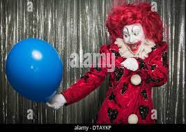A Clown Getting Ready To Pop A Balloon With A Needle Stock Photo Alamy