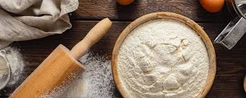 제빵사가 스톤 밀에서 갓 쏟아져 나오는 따뜻하고 고소한 통밀가루의 상태를 손으로 만져보며 확인하는 모습