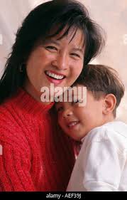 A mom holds a two-year-old child in her arms and she points her finger at a  bow Stock Photo