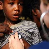 A young girl receives a dose of deworming medicine