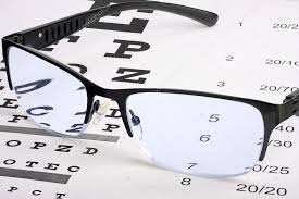 Eye Glasses With Thin Frame Lying On Snellen Chart Stock