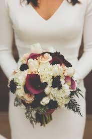 Sometimes the flowers are all you need to create a wedding design and the small calla lilies are perfect for creating a simple design to carry. Bridal Bouquet Winter Bride Winter Wedding Winter White Scabiosa Calla Lily Winter Greens Hydrangea Flower Bouquet Wedding Burgundy Bouquet Glam Wedding