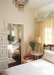 Soften a crisp white bedroom design with sheer white drapes on a canopy bed. Feminine Bedrooms Design Ideas