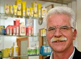 Anton Becker vor einer Spiegelvitrine mit Produkten des