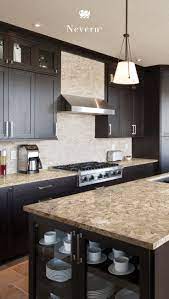 The design scheme includes a honed bianca perla quartzite stone, painted cabinets, and wrought iron pulls. Dark Wood Cabinets Pair With The Cream Taupe And Dusty Brown Tones I Kitchen Cabinet Color Schemes Medium Wood Kitchen Cabinets Backsplash With Dark Cabinets