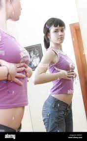 Teenager girl looking at mirror and checking her breast Stock Photo - Alamy