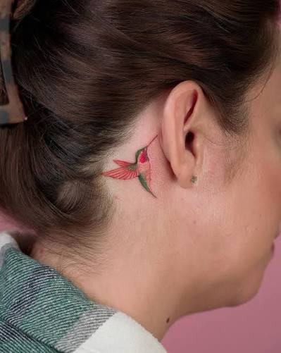 A delicate hummingbird tattoo nestled behind Erika's ear as a touching tribute to her grandmother since hummingbirds held a special place in her grandmother's heart. This tattoo could symbolize the enduring love,
