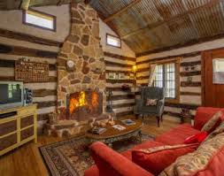 This cabin, surrounded by trees, overlooks barons creek. The Swiss Log Cabins The Enormously Romantic Swiss Log Cabins At Barons Creekside Have A Unique History Daniel The Swis Log Cabin Cabin Fredericksburg Texas