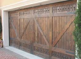 This tuscan style garage door was handcrafted in solid rustic alder wood with an oil rubbed finish and decorative iron hardware. Gabriel Barn Style Custom Wood Garage Door Etsy