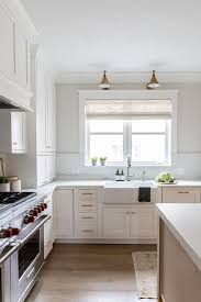 Simple white cabinets and clean silver hardware work well alongside wooden countertops and light colored wall paint. Cream Kitchen Cabinets Brass Hardware Design Ideas