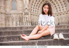 Стоковая фотография 1221834889: Young Attractive Asian Girl Sitting  Barefoot | Shutterstock