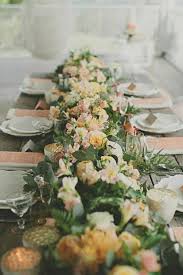 chemin de table bien fourni en fleurs et en verdure avec un peu de lumieres venant des quelques photop centre de table mariage table mariage deco table mariage