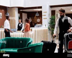 Gambar Bellboy assisting a guest with their luggage
