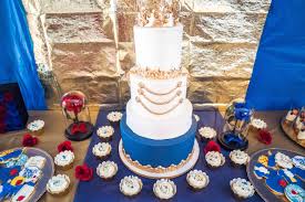 A rustic boy's baby shower dessert table with navy candles, white floral arrangements, letters on the backdrop and sweets. Beautiful Baby Shower Dessert Tables To Recreate