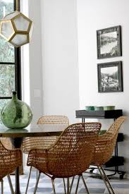 Wicker Dining Chairs Paired With Modern Sleek Dining Room And Gold Pendant Lamp Wicker Dining Chairs Modern Dining Room Dining Room Inspiration