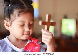 Little Boy Praying Holding Wooden Cross Stock Photo 1106058755