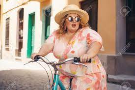 Curvy, Plus Size, Active, Big, Chubby Woman Riding A Bike Down A Street.  Generative AI. Stock Photo, Picture and Royalty Free Image. Image 205428355.