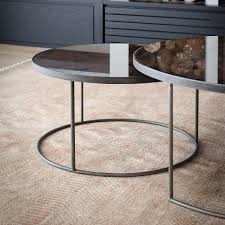 A nesting coffee table with a set of two rounded triangular shapes featuring mixed material tabletops. Notre Monde Round Nesting Coffee Table Bronze Ethnicraft