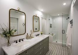 In this bathroom, white coats every surface, except the wood vanity, to maximize the bright, expansive effect. Gray And White Cottage Bathroom With Gold Mirrors Hgtv
