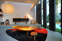 1941 table en noyer massif à plateau avec un léger galbe, bord en biais avec rehaussement, reposant sur 4 pieds fuselés réunis par une entretoise centrale modèle unique d'une commande spéciale. Charlotte Perriand Wikipedia