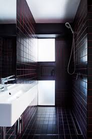 The Bathroom Is Clad With Black Tiles And Red Grout For A Stylish Masculine Inspired Look Micro Apartment Bathroom Red Bathroom Interior Design