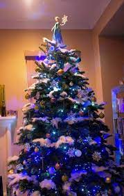The tree is lit with clear lights. Disney S Frozen Inspired Christmas Tree With Elsa Tree Topper The Best I Have Seen So Far L Frozen Christmas Tree Blue Christmas Decor Christmas Tree Themes