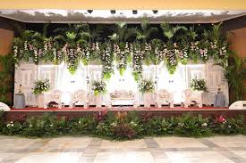 Efek glamor biasanya dihadirkan melalui hiasan dari kristal atau swarovski sebagai dekorasi pelaminan, misalnya lampu gantung. Dekorasi Pelaminan Tanpa Gebyok