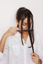 Part your bangs into three subsections: How To Cut Your Own Bangs A Cup Of Jo