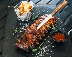 Friptura de porc glazurata cu mustar, miere si bere, extra frageda si rumena. Coaste De Porc Caramelizate Cu Wedges Dada Restaurant