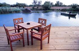 Wood Deck With Table Four Wooden Chairs And A Table Standing On A Wooden Dock A Spon Table Wooden Wood Wood Deck Wooden Chair Outdoor Furniture Sets
