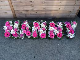 They are always hand delivered by the florist a couple of hours prior to the funeral. A Contemporary Styled Tribute Spelling Out Nanny Using Pink Gerbera Aqua Roses And Cymbidium Orchids Funeral Floral Arrangements Funeral Floral Pink Gerbera