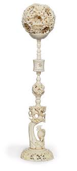 Chinese carved ivory puzzle ball and a figural. A Chinese Ivory Puzzle Ball And Stand