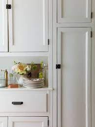 The wood floors ground the design with a slightly darker tone, contrasting the rest of the bright finishes. Black Hardware Kitchen Cabinet Ideas The Inspired Room