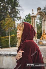 Limitations and fees may apply. Side View Of Brunette Girl In Red Hood Posing Over Arch Statue On Background Woman Peace Stock Photo 176672158