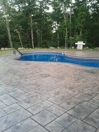 Stamped concrete is a popular decking material for pool surrounds because it is affordable, durable and attractive. Enjoy The Summer With A New Stamped Concrete Pool Deck Grand Ashlar Slate Pattern Sandstone Charcoal A Pool Landscaping Swimming Pool Landscaping Pool Paving