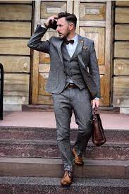 Fall outfit layering inspiration with a green waistcoat navy suit blue striped shirt brown silk patterned tie sunglasses brown gloves watch brown/olive jacket dark brown shoes. Primark Primania Street Style That Dapper Chap Wearing Grey Suit With Matching Waistcoat Shirt Mens Fashion Suits Wedding Suits Men Hipster Mens Fashion