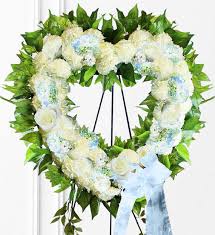 This heartfelt arrangement features blue hydrangea, white spray roses, and variegated ivy. Blue Sympathy Heart Wreath Avas Flowers