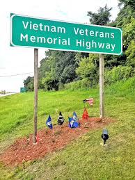Couple keeps veterans sign area trim and tidy